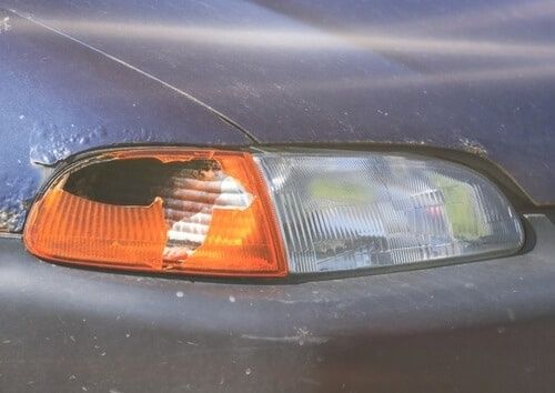 Närbild av bilens främre strålkastare med orange blinkers